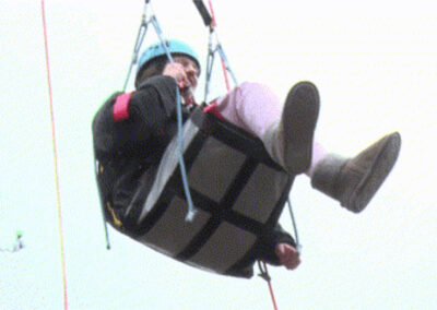 The young wheelchair user has now been hoisted up into the air and is laughing and enjoying the view.