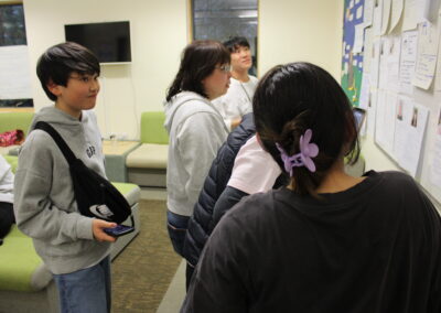 Young Japanese delegates look at profiles on the wall to find out about the other people at the conference