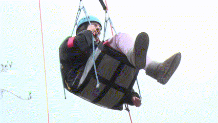 The young wheelchair user has now been hoisted up into the trees and is laughing and enjoying the view.